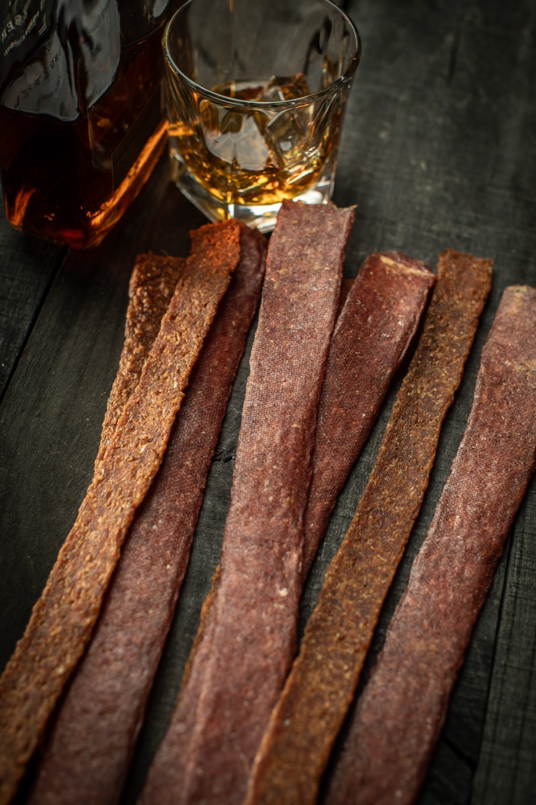Strips of seasoned carp jerky on dark wood